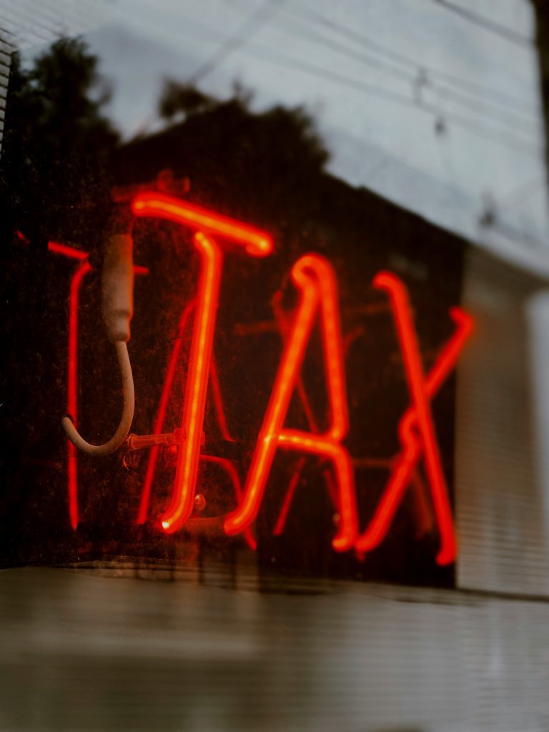 auf dem bild ist eine Leuchtreklame mit der Schrift TAX zu sehen