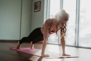 Frau hält sich auf einer Yogamatte in der Planke