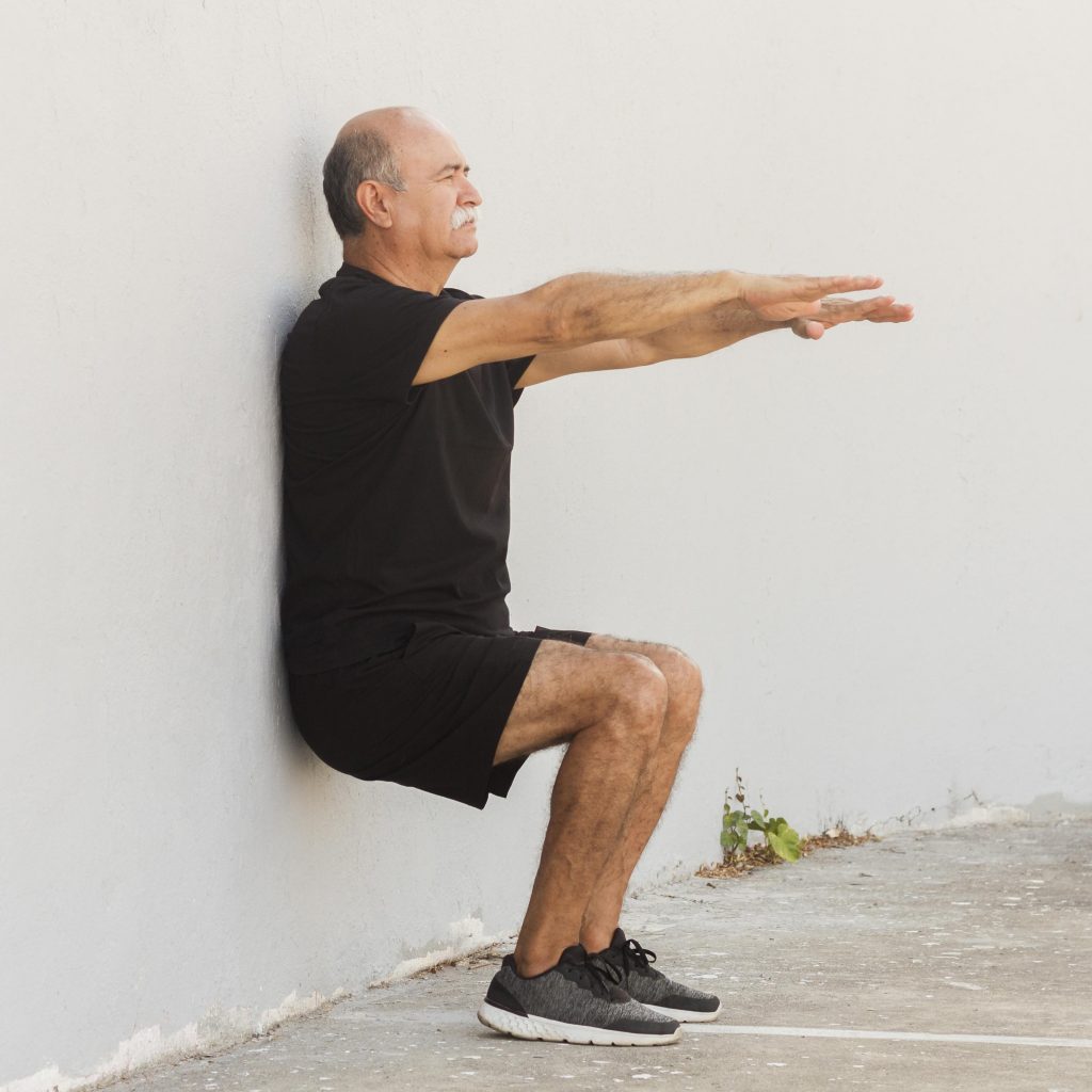 älterer Mann sitz an der Wand